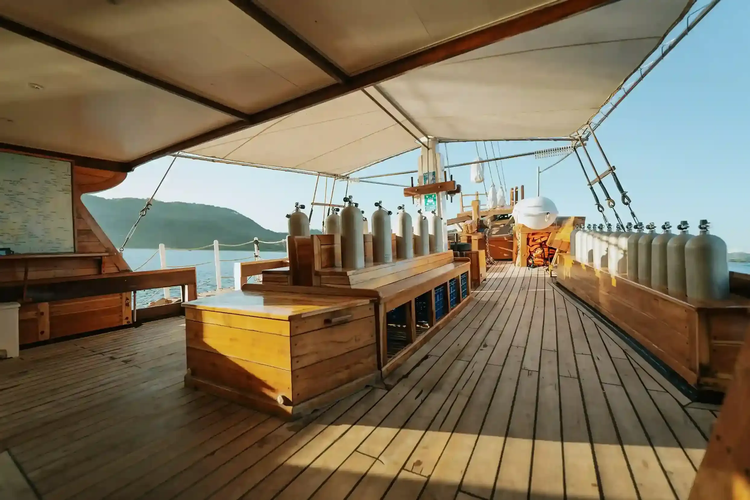 Dive tanks and gear on a liveaboard deck in Komodo