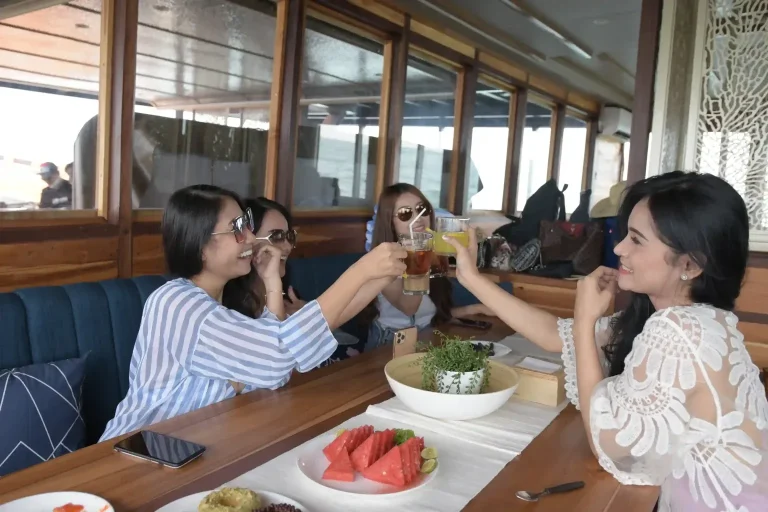 Friends enjoying drinks together on a Komodo charter boat