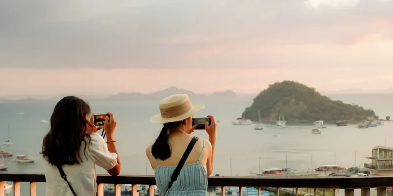 Tourists overlooking Labuan Bajo harbor at sunset
