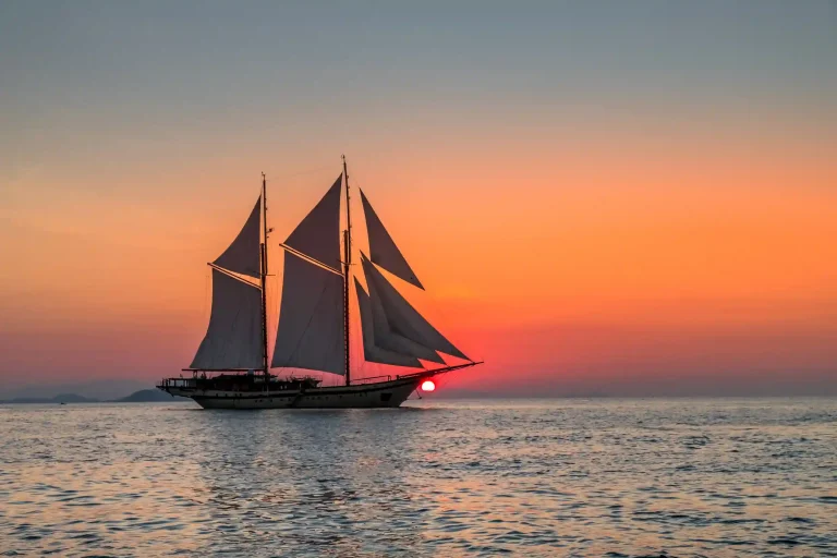 Traditional phinisi sailing at sunset off Komodo