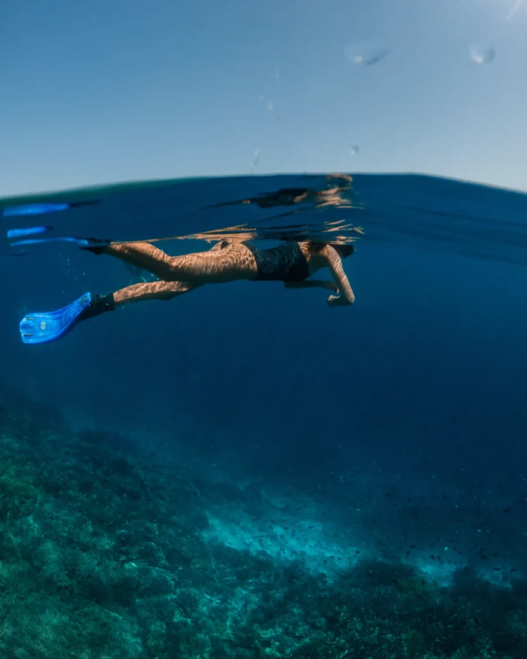 Snorkeler with fins over a reef in Komodo